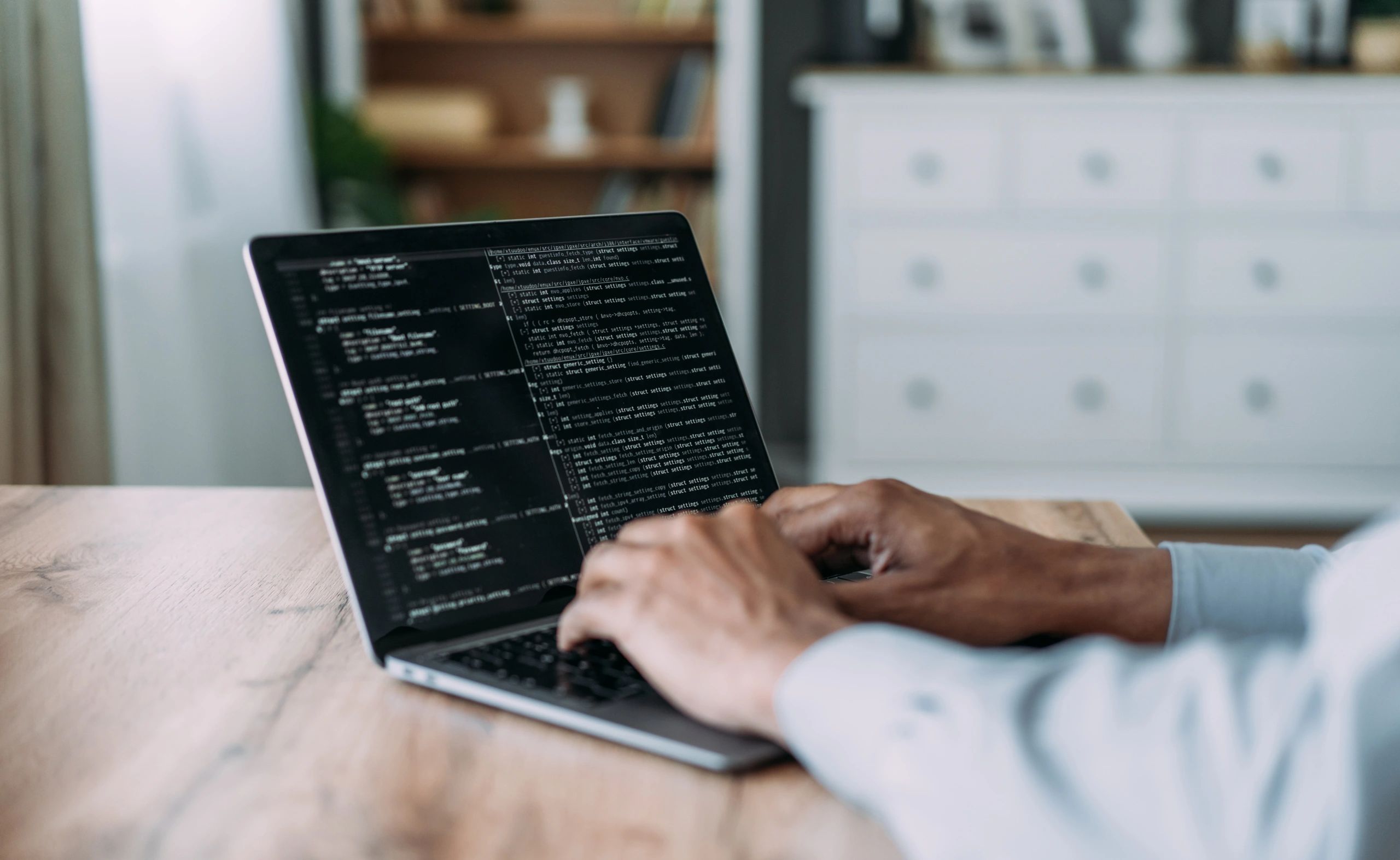 Person working on a laptop at home office